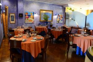 a dining room with tables with orange table cloths at Hotel Tikar in Garrucha