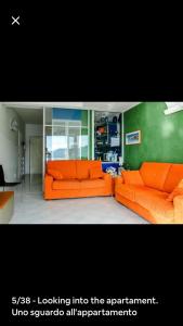 Appartamento Villa Panorama في مورتولا إنفريوري: غرفة معيشة مع أريكة برتقالية في غرفة