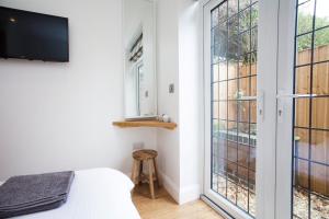 a bedroom with a bed and a window at The Woodpecker Snug in Nottingham