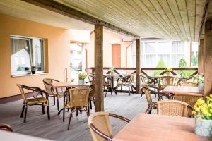 an empty patio with tables and chairs in a restaurant at Ramybes sala in Palanga