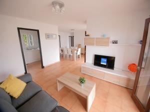ein Wohnzimmer mit einem Sofa und einem TV in der Unterkunft Villa Binicudi in Binibeca