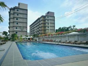 a swimming pool in front of two tall buildings at The Mangrove Hotel in Na Jomtien