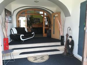 a living room with a black and white chair and a door at Penzion Tomy Pihlov in Horní Planá