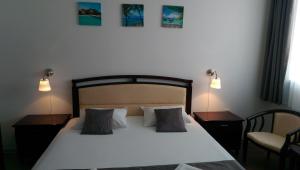 una camera con un letto con due lampade e una sedia di Garsoniera Papaya Beach a Mamaia Nord - Năvodari