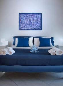 a blue bed with pillows and a picture on the wall at Villa Fraele in Acireale