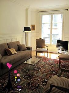 a living room with a couch and a rug at Champs Elysees Argentine CityCosy in Paris
