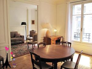 パリにあるChamps Elysees Argentine CityCosyのリビングルーム(テーブル、椅子、ソファ付)