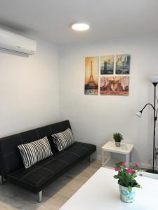 a living room with a black couch and a table at Aiguaneu Sa Carbonera in Blanes