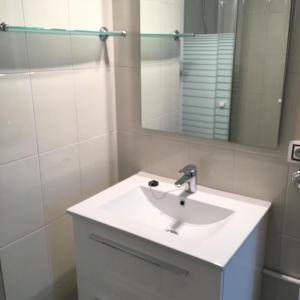 La salle de bains est pourvue d'un lavabo blanc et d'un miroir. dans l'établissement Aiguaneu Sa Carbonera, à Blanes