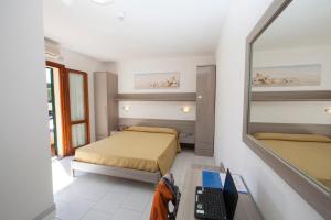 ein Schlafzimmer mit zwei Betten und einem Laptop auf einem Schreibtisch in der Unterkunft Hotel Da Italo in Seccheto