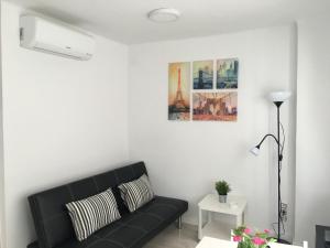 a living room with a black couch and a picture at Aiguaneu Sa Carbonera in Blanes