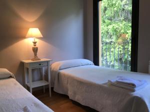 two beds in a room with a window at Apartamento Balcon De Jaca I in Jaca