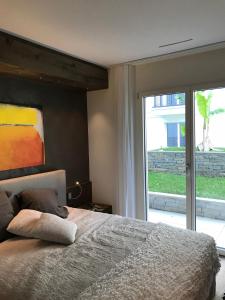 a bedroom with a bed and a large window at Appartement Suite Delta Resort in Ascona