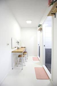 Cette petite chambre blanche dispose d'une table et de chaises. dans l'établissement Zibro S, à Séoul