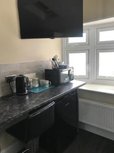 a kitchen with a counter top with a microwave at Cauldwell Villas in South Shields