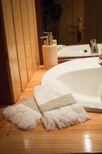 - Baño con lavabo y toallas en el suelo en Turismo Rural O Xastre de Anos en Cabana de Bergantiños
