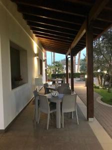 een patio met een tafel en stoelen op een veranda bij Villetta Del Salento Exclusive B&B in Gallipoli