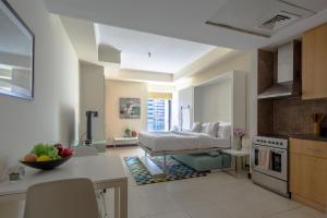 a kitchen and living room with a bed in the background at Frank Porter - Goldcrest Views in Dubai