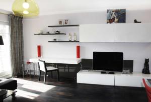 een woonkamer met een bureau en een televisie bij Residenz "Zum Kronprinzen" Wohnung Nr.10 in Bad Saarow