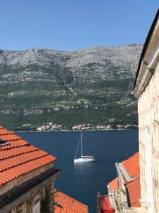 a sail boat in the water between two buildings at Moro Apartment in Korčula