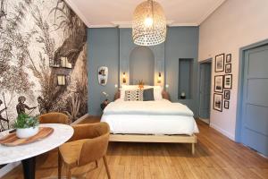 sypialnia z łóżkiem, stołem i krzesłami w obiekcie La chouette d'or w mieście Dijon