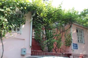 una casa con una puerta roja y algunos árboles en Hostel Old City Sololaki en Tiflis