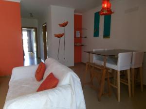 a living room with a white couch and a table at Casa das Dunas Soltroia in Troia