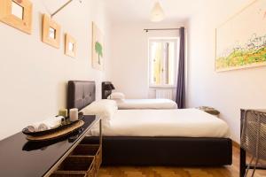 2 letti in una camera con pareti bianche di ROMAC Condotti with 3 bedrooms near the Spanish Steps a Roma