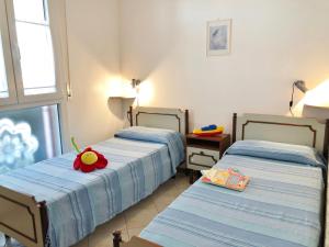 sypialnia z 2 łóżkami i czerwonym kwiatem na łóżku w obiekcie Casa Pola w Grado