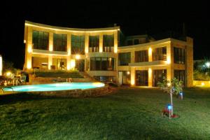 a large house with a swimming pool at night at Castle on the edge of the sea in Nea Potidaea