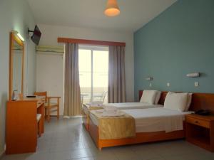 A bed or beds in a room at Bayside Hotel Katsaras