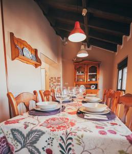 una mesa de comedor con platos y copas de vino en La Aldea Colorada Casa Rural, en Mota del Marqués