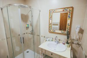 y baño con ducha, lavabo y espejo. en La Aldea Colorada Casa Rural, en Mota del Marqués