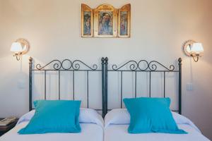 a bed with two blue pillows on top of it at La Aldea Colorada Casa Rural in Mota del Marqués