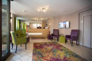 ein Wartezimmer mit grünen und violetten Stühlen und einem Teppich in der Unterkunft Hotel zur Pfalz in Kandel