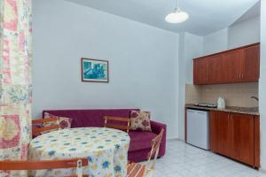 a small kitchen with a table and a purple couch at THE S APART & SUITES hOTEL in Alanya