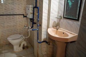 um banheiro com vaso sanitário e pia em Brown Bread Bakery Guest House em Varanasi