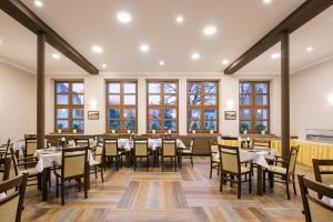 - une salle à manger avec des tables, des chaises et des fenêtres dans l'établissement Hotel Grand, à Doksy