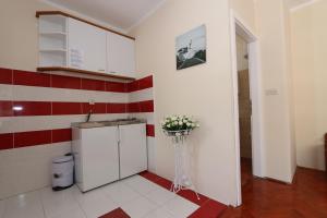 a small kitchen with a sink and a vase of flowers at Apartmani Aron in Novalja