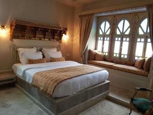 a bedroom with a large bed and two windows at Maison d'Hôtes Dar Ennassim in La Marsa