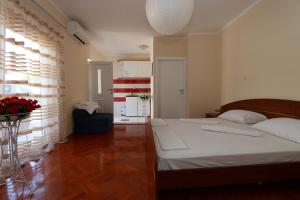 a bedroom with a large white bed in a room at Apartmani Aron in Novalja