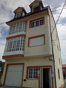 un edificio alto con una torre encima en CASA Beirada Monte y Playa, en Carnota