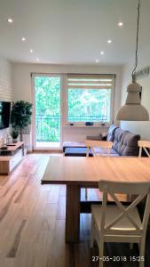 a living room with a table and a couch at Blue Mare Apartamenty U Tomka in Łukęcin