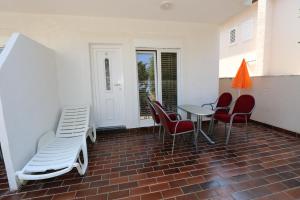 a patio with chairs and a table and a table and chairs at Apartmani Aron in Novalja