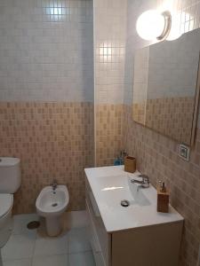 y baño con lavabo, aseo y espejo. en TRIANA PUREZA 1, en Sevilla