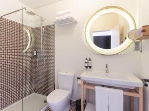 a bathroom with a toilet, sink and mirror at The House of Sandeman - Hostel & Suites in Vila Nova de Gaia