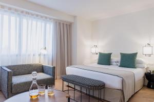 ein Hotelzimmer mit einem Bett und einem Stuhl in der Unterkunft Molina Lario in Málaga