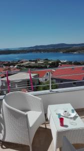a balcony with a table and chairs and a view of the water at Apartments Sky in Šibenik