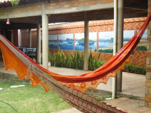 an orange hammock in front of a building at Toca do Vaidoso in Barreirinhas