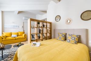 um quarto com uma cama amarela e um sofá amarelo em Les Suites de Saint Amand em Bordeaux